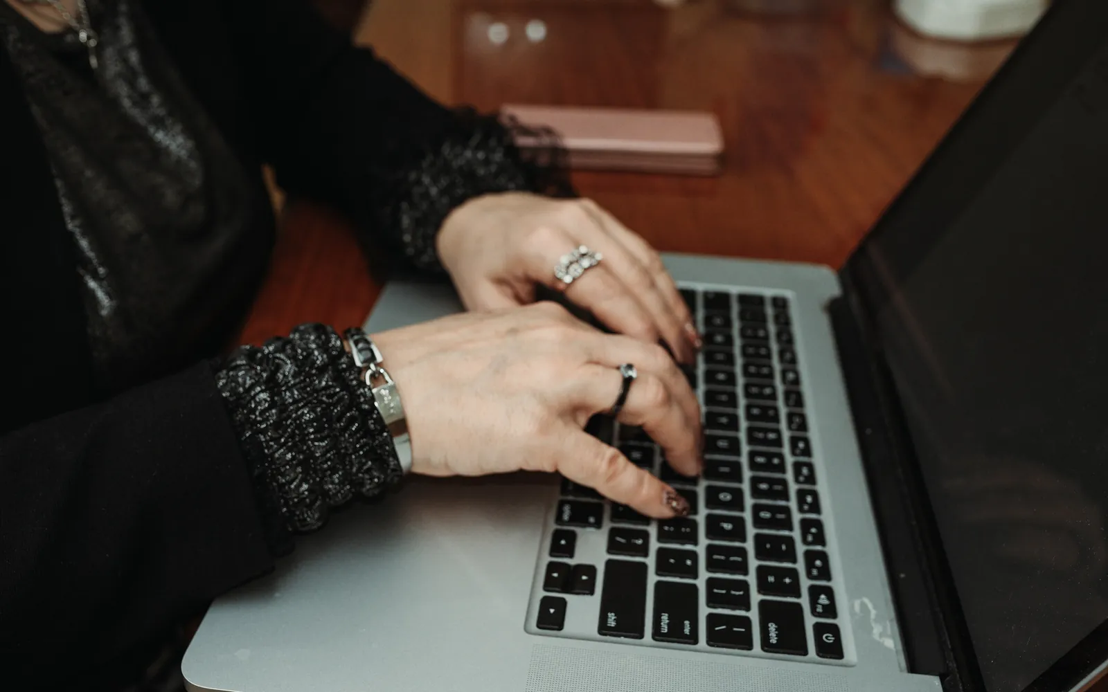 Close-up of hands typing on a laptop keyboard