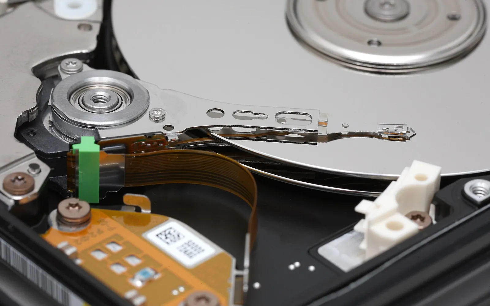 The inside of an opened hard disk drive showing the platters and read/write head arm