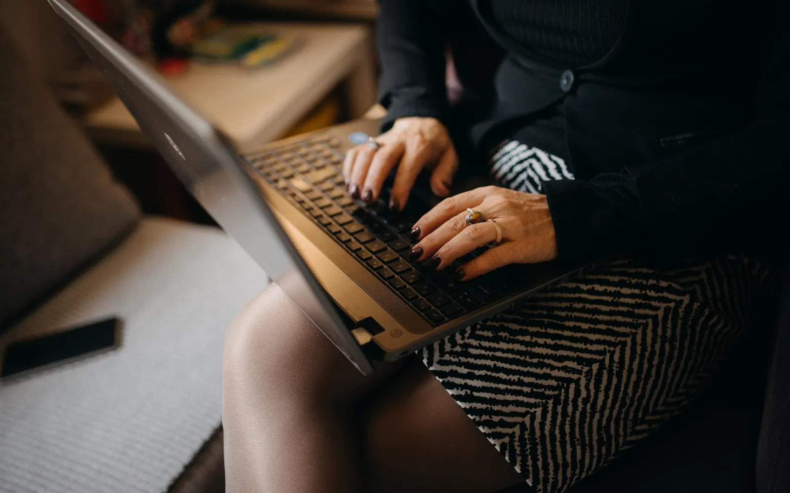 A laptop resting on a lap while someone types