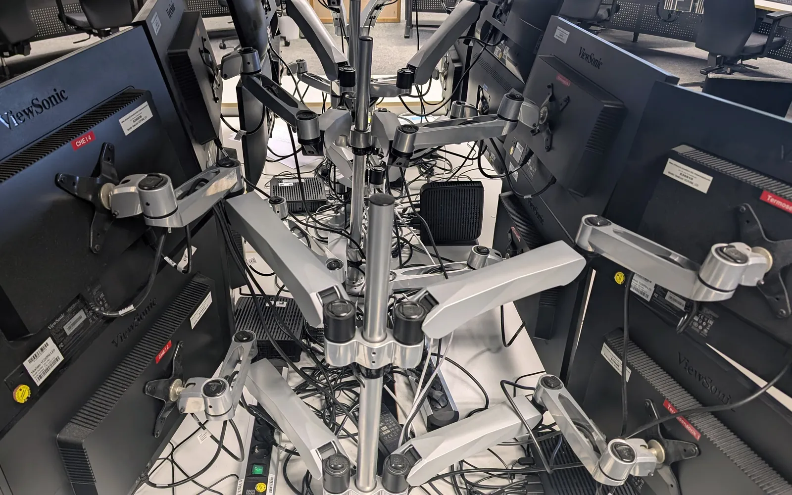 Rows of monitors on adjustable arms in a control room